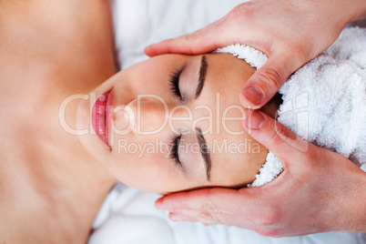 Young pretty woman getting face massage in spa