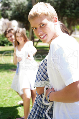 Happy Friends pulling a rope against each other