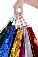 Colorful shopping bags holding by human hand