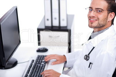Smiling young doctor working on his desk