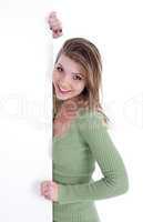 Happy young women peeking through a blank board