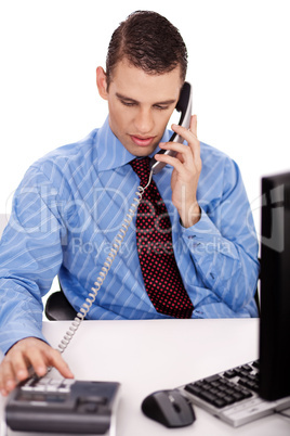 young business man sitting at his desk talking over phone