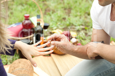 Man puts the ring in love to her girlfriend, hands on focus