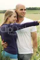 Young couple in meadow with the hands in the air, hugging