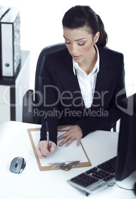 Busy business lady making her notes on the clipboard