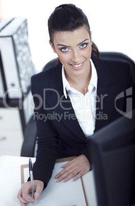 Attractive woman writing on clipboard
