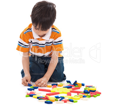 Adorable caucasian boy joining the blocks while playing