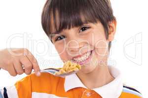 Smiling young boy with spoon of flakes, closeup