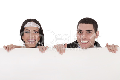 Newly married couple standing behind the board