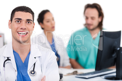 Happy young doctor in focus, two others in out of focus