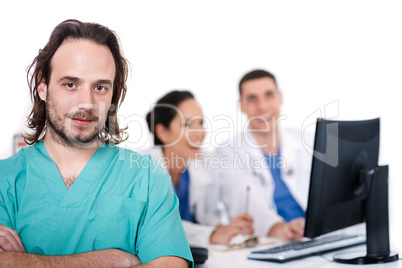 Male doctor on focus, two doctors discussing at background