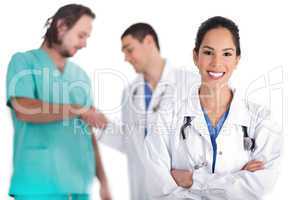 Attractive young doctor smiling, other doctor giving shake hand to male nurse
