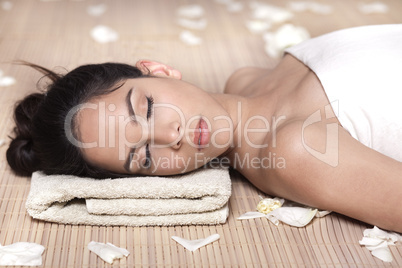 Beautiful lady with white flowers in spa treatment