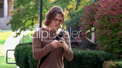 Students texting while walking on campus.