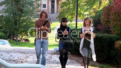 Students texting while walking on campus.