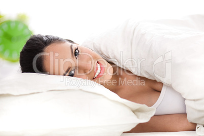 Portrait of beautiful smiling woman on bed at bedroom