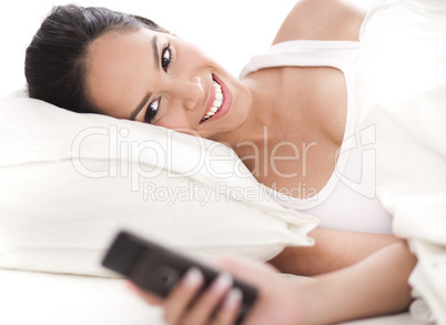 Woman looking at the mobile as she woke up