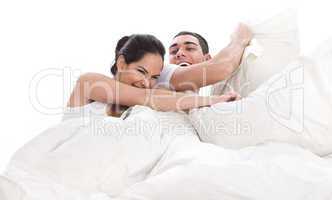 Playful young beautiful couple with pillows