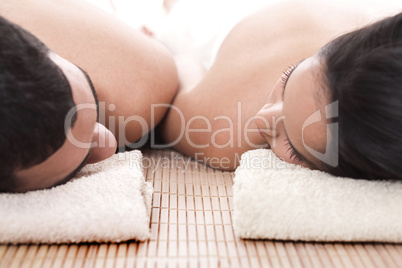 Young man and woman lying on towel to take spa