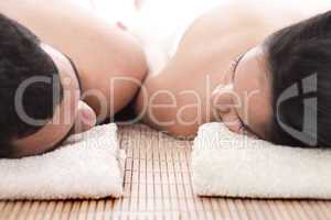 Young man and woman lying on towel to take spa