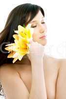 brunette with yellow lily flowers in spa
