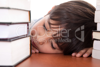 School boy tired of studying and sleeping with books