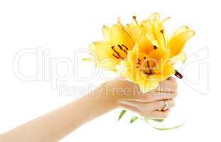 female hand holding yellow madonna lily bouquet