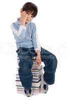 Young boy sitting over tower of books