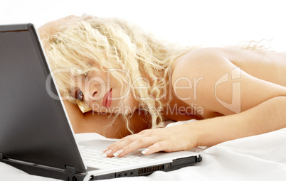 portrait of blond laying in bed with laptop