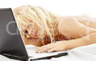 portrait of blond laying in bed with laptop