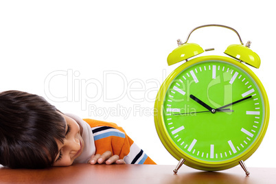 Boy tired of study and sleeping near the clock