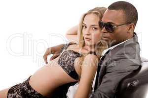 Sexy lady lying on the young business man in couch