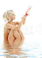 naked blond with rose petals in water