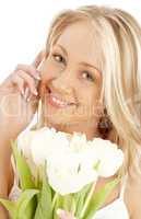cheerful blond with white tulips and phone
