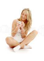 teenage girl sitting on the floor with a white phone