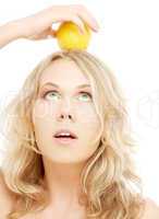 healthy blond holding lemon on her head