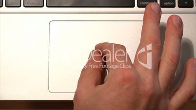 Demonstrating the various uses of a laptop's multi-gesture trackpad.
