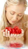 lovely blond in water with red rose petals