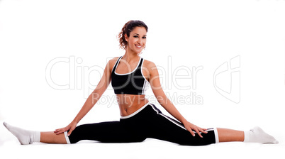 Fitness girl sitting and streching her legs both sides
