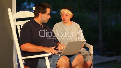 A boy helps his father use the computer.  Actually, that could be his uncle.  But really, it doesn't matter--right?  This is stock footage; it can be anything you need it to be.