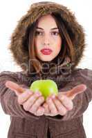 Beautiful young lady showing green apple wearing a fur coat with