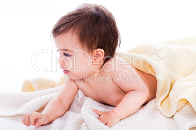 Infant lying under the yellow towel