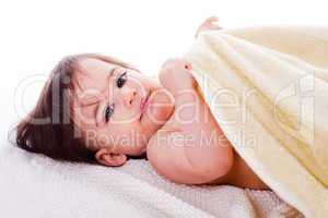 Little baby lying in white towel and wrapped with yellow towel