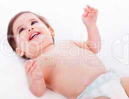 Playful baby lying with has hands up