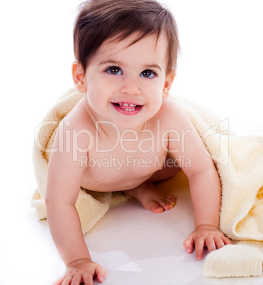 Baby showing its teeth under yellow towel
