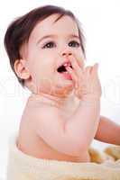 Baby with finger in mouth looking up