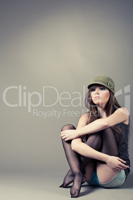 Beautiful young girl sitting with her knees pulled up