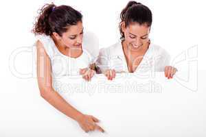 Business woman pointing a blank board to her colleague