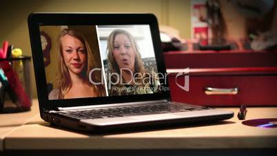 Two women video chat on a portable laptop computer.