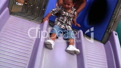 A young boy slides down a sliding board.